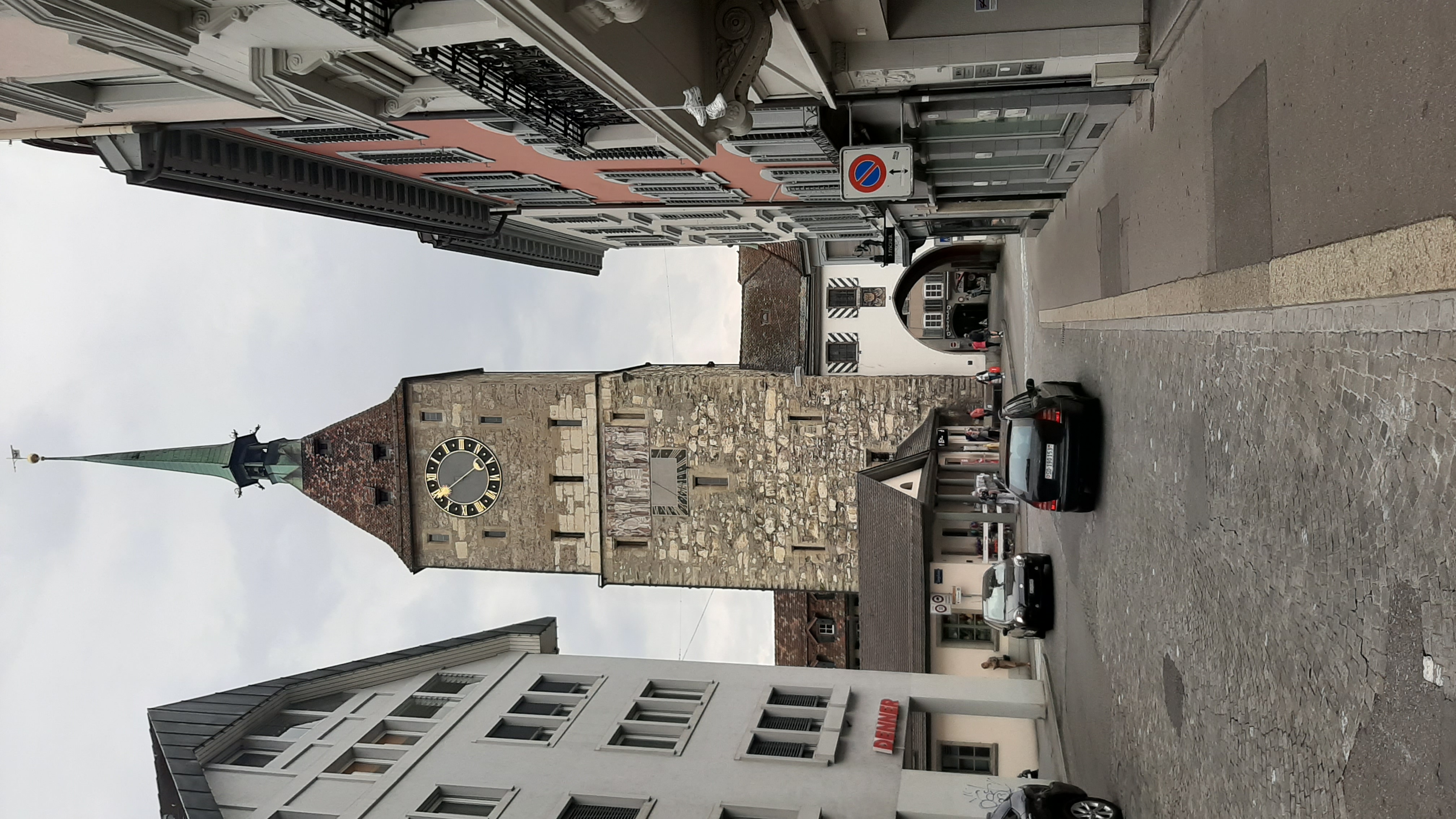 Narrow old-town street leading to a clock tower gate