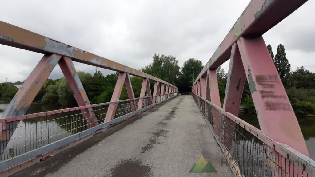 Pink steel footbridge over the river in the morning